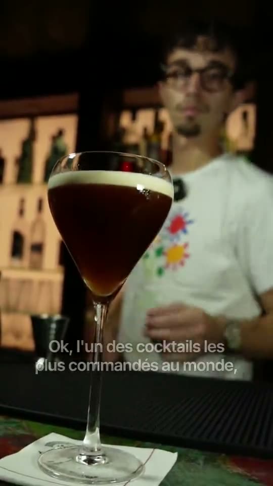 Verre d'Expresso Martini au premier plan, derrière le bar